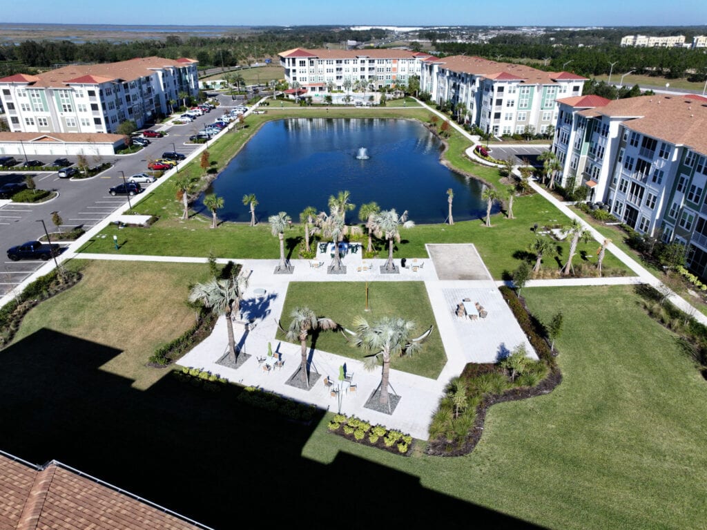 Luxury apartment complex with a central water fountain and landscaped outdoor communal area.