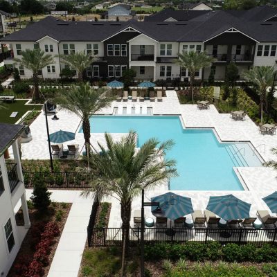 Modern residential apartment complex with outdoor pool and landscaped courtyard.