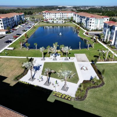 Luxury apartment complex with a central water fountain and landscaped outdoor communal area.