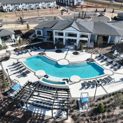 Luxury residential swimming pool with surrounding hardscapes and lounge area.